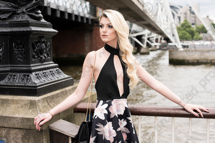 HWP9063 
 Fashion editorial shot of Blonde wearing a black halter top
looking to her right 
 Keywords: Blonde, fashion,editorial, outdoors,city,halter neck dress, black dress